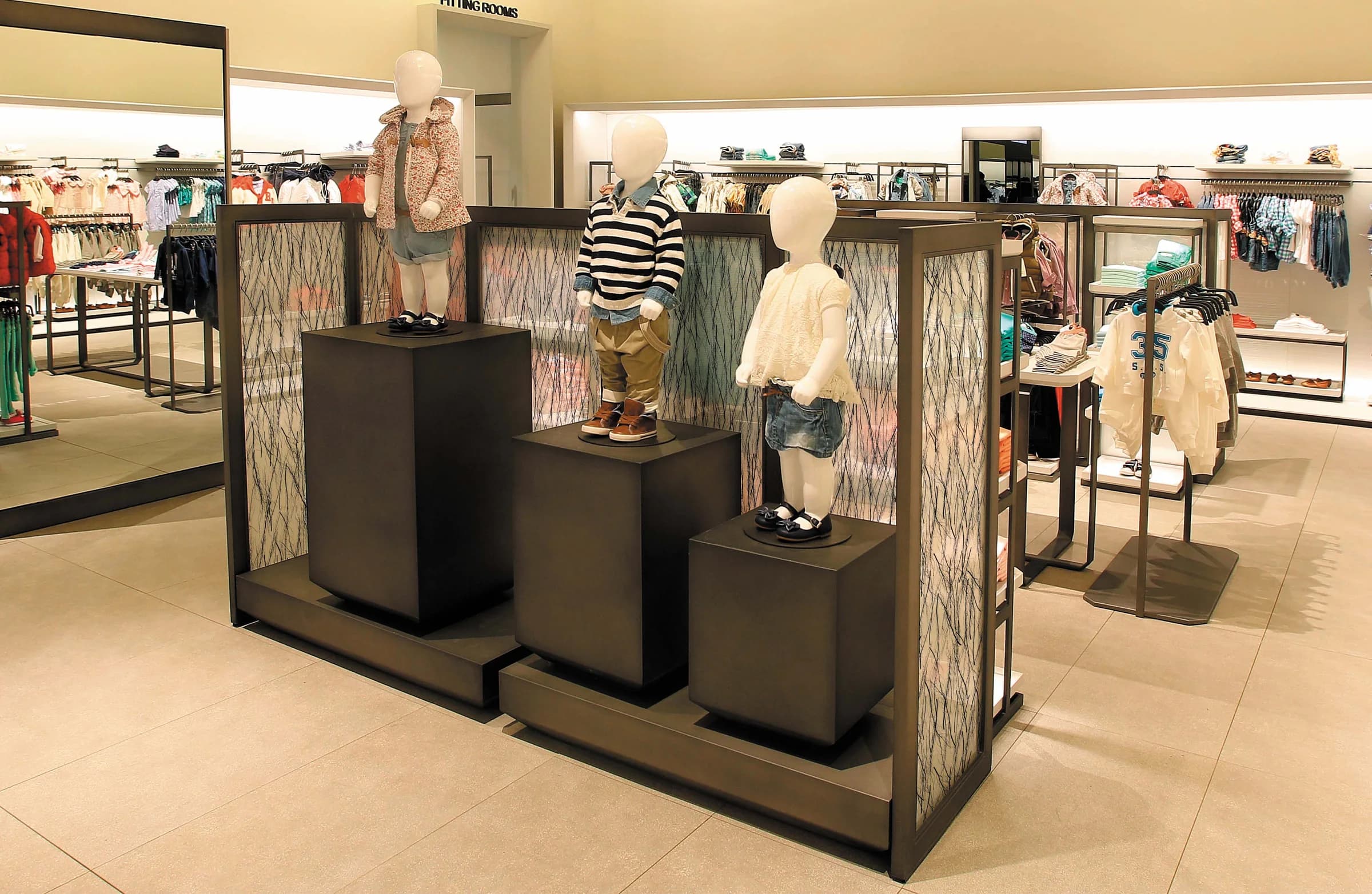 Retail fixtures wrapped in Fusion LuxCore panels printed with a birch-forest image in a children's clothing store.