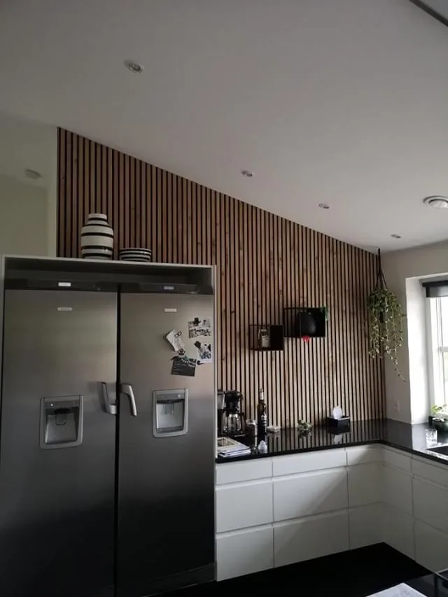 Akupanel slats on a kitchen wall above open shelving.