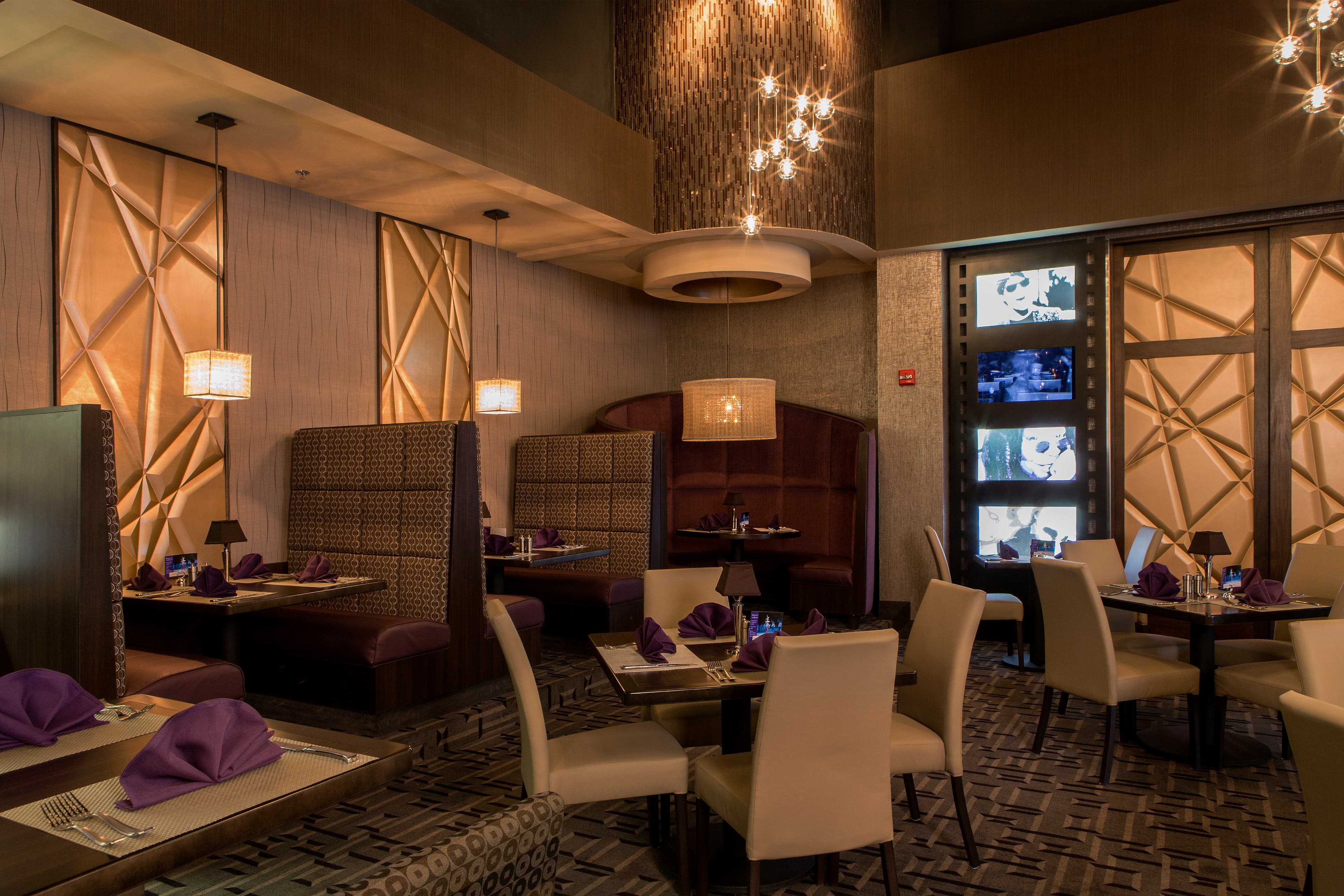 Interlam surfaces in use, from carved ForesCOLOR waves to backlit carved screens in a restaurant.