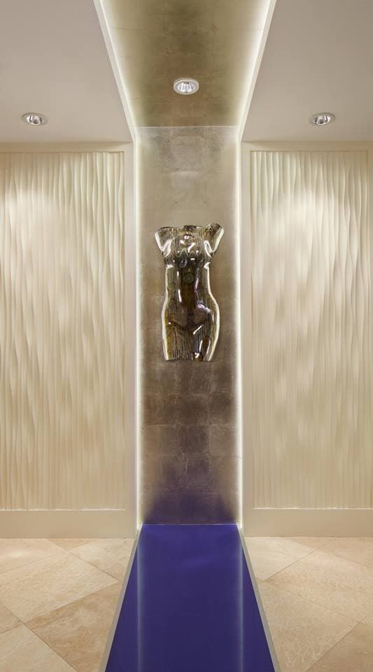 Art Diffusion wave panels lining a narrow hall with a sculpture at its end.