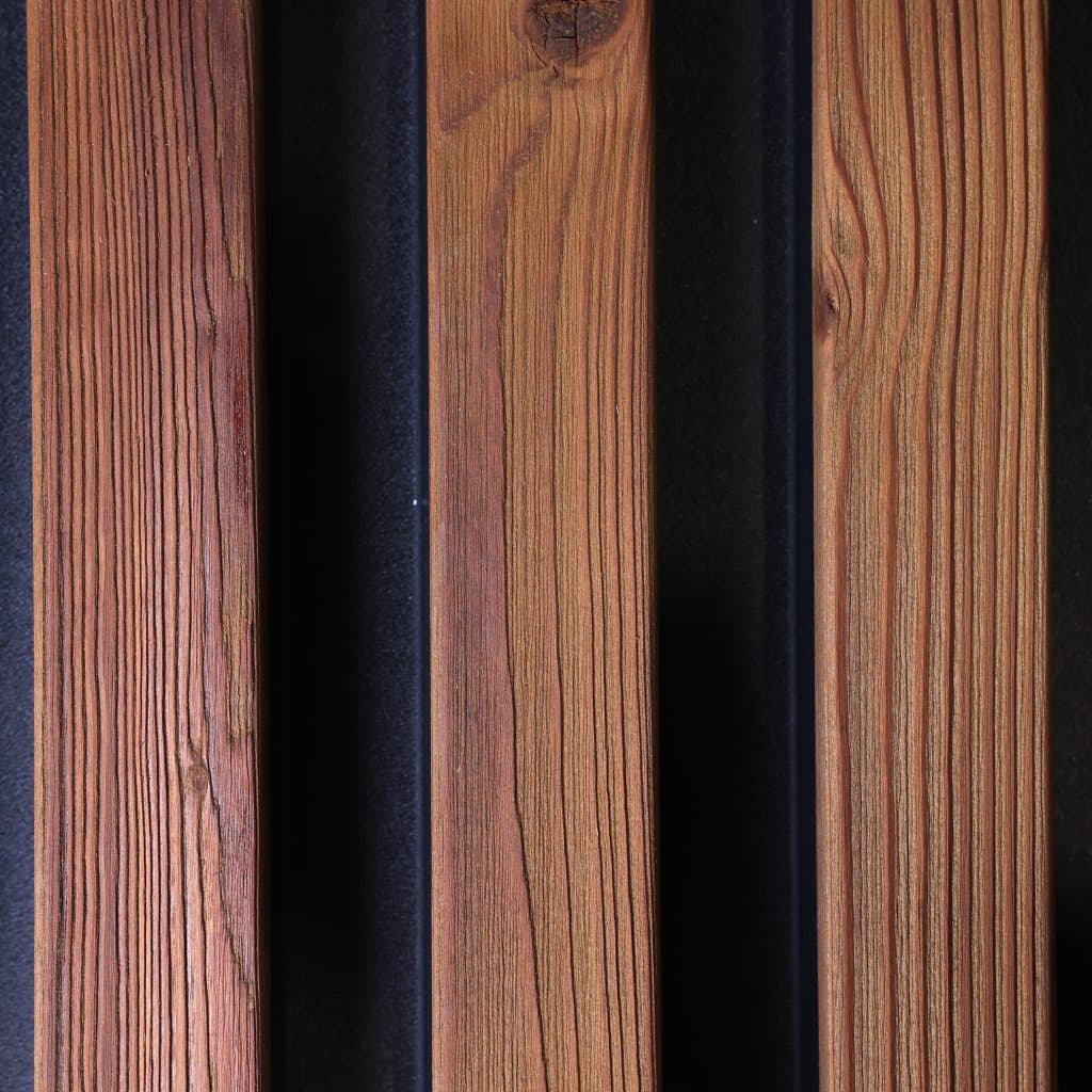 Aluwood Oiled Brown sample: thermally modified pine slats on a black aluminum backing.